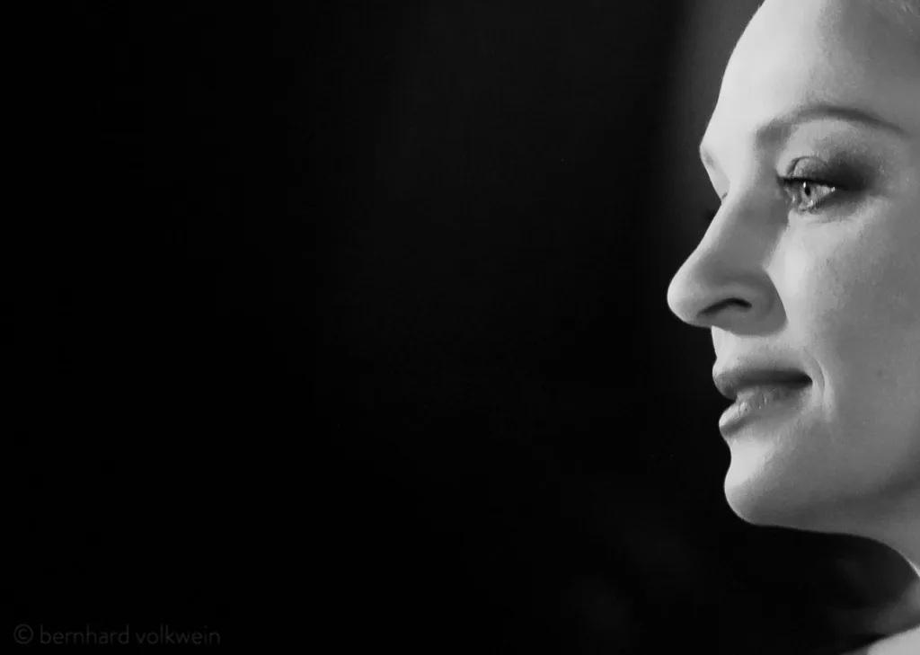 Elegant black and white profile of Uma Thurman at Cinema for Peace, shot with sculptural lighting – timeless portrait from the exhibition 'The Unseen Scene'.