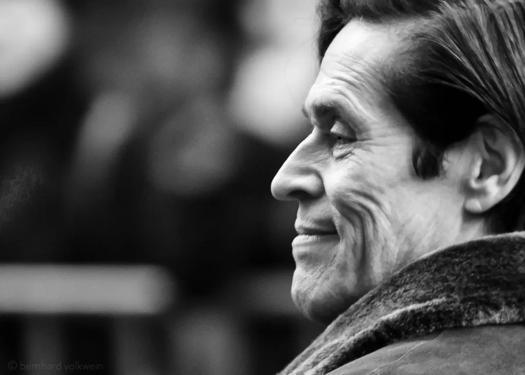 Soft-lit black and white portrait of William Dafoe at Berlinale, revealing wisdom and serenity – part of the exhibition 'The Unseen Scene'.