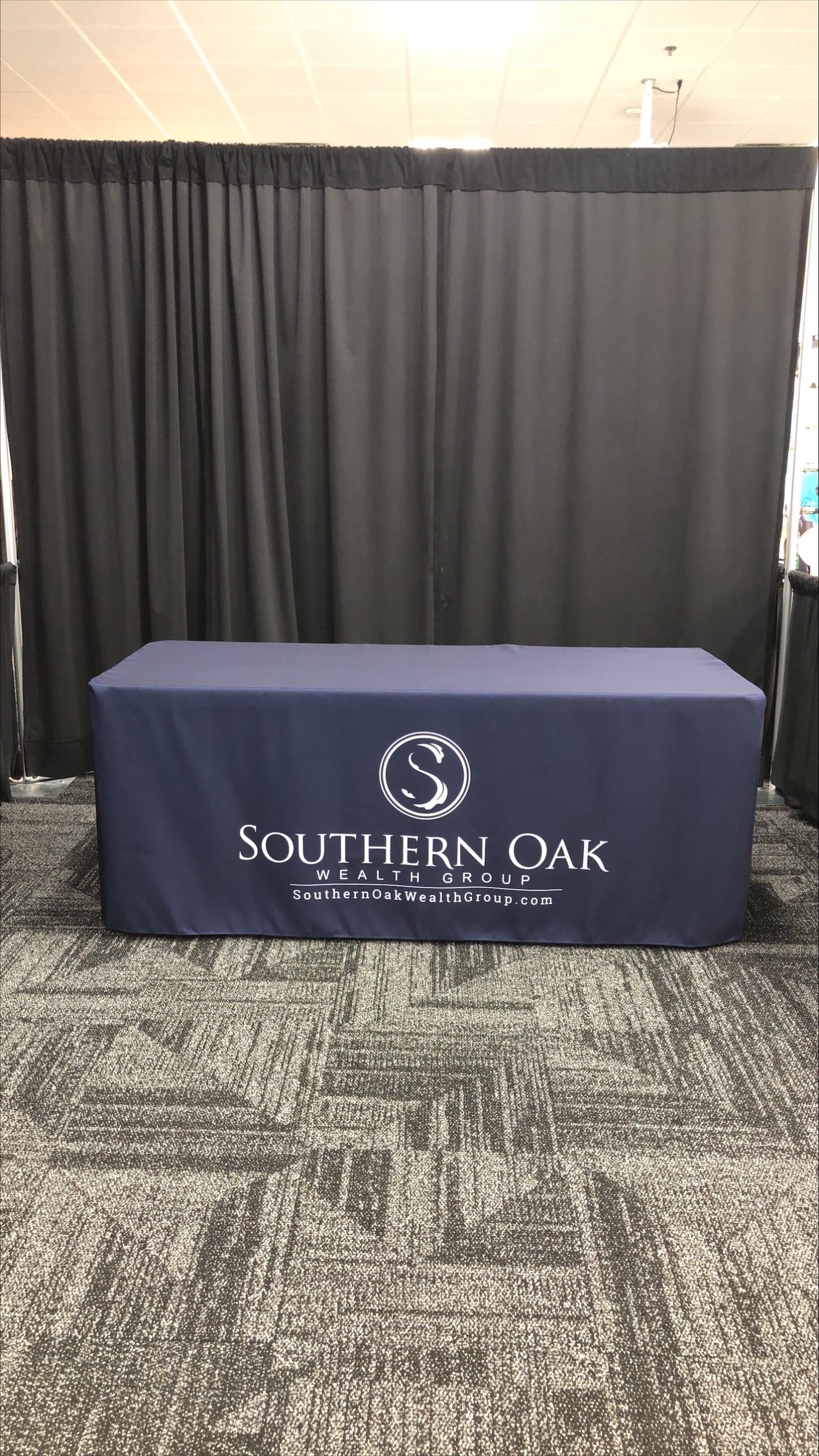 A tablecloth featuring the company logo prominently printed on the front to attract the attention of passersby.