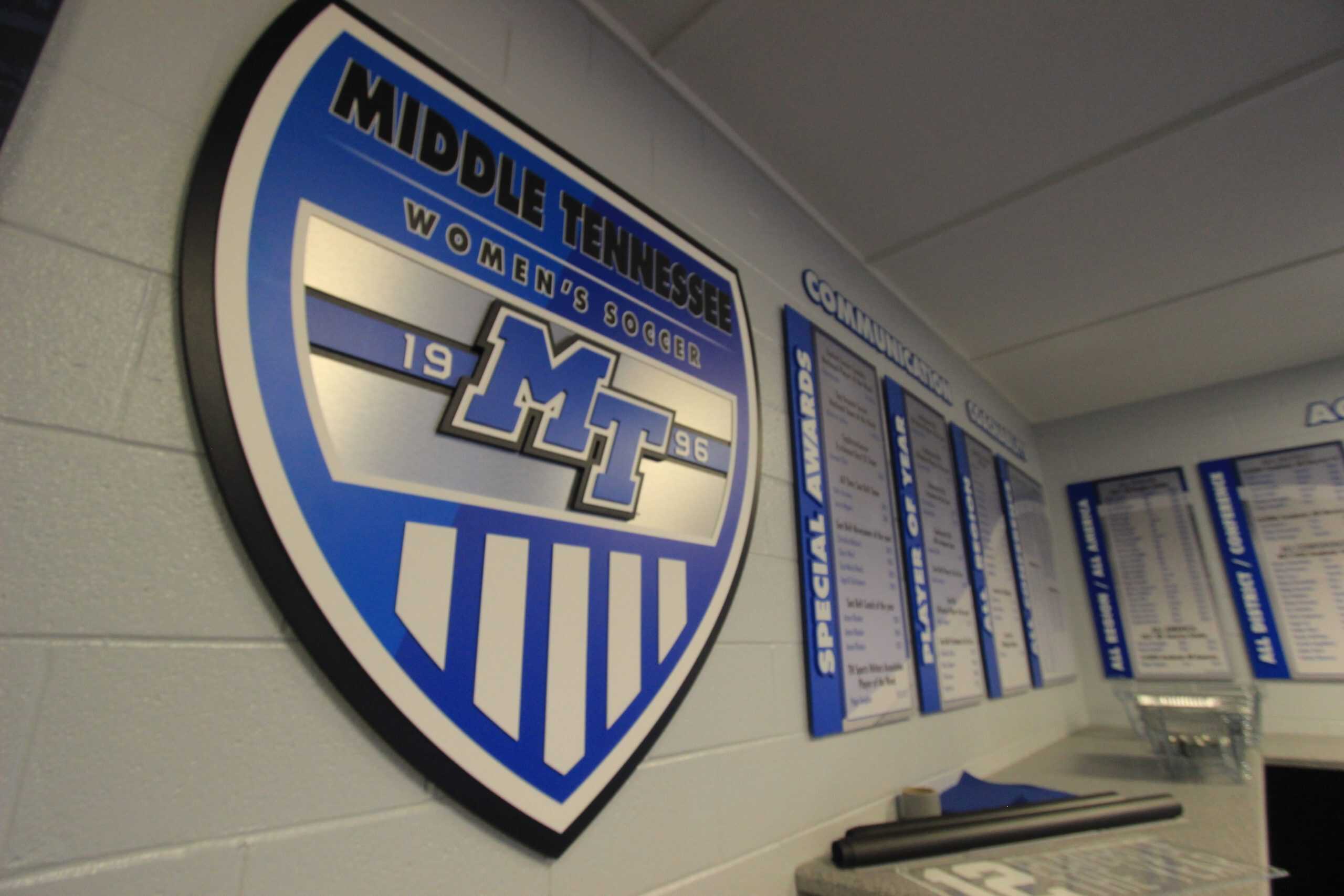 Middle Tennessee Women's Soccer emblem and awards on a light gray wall.