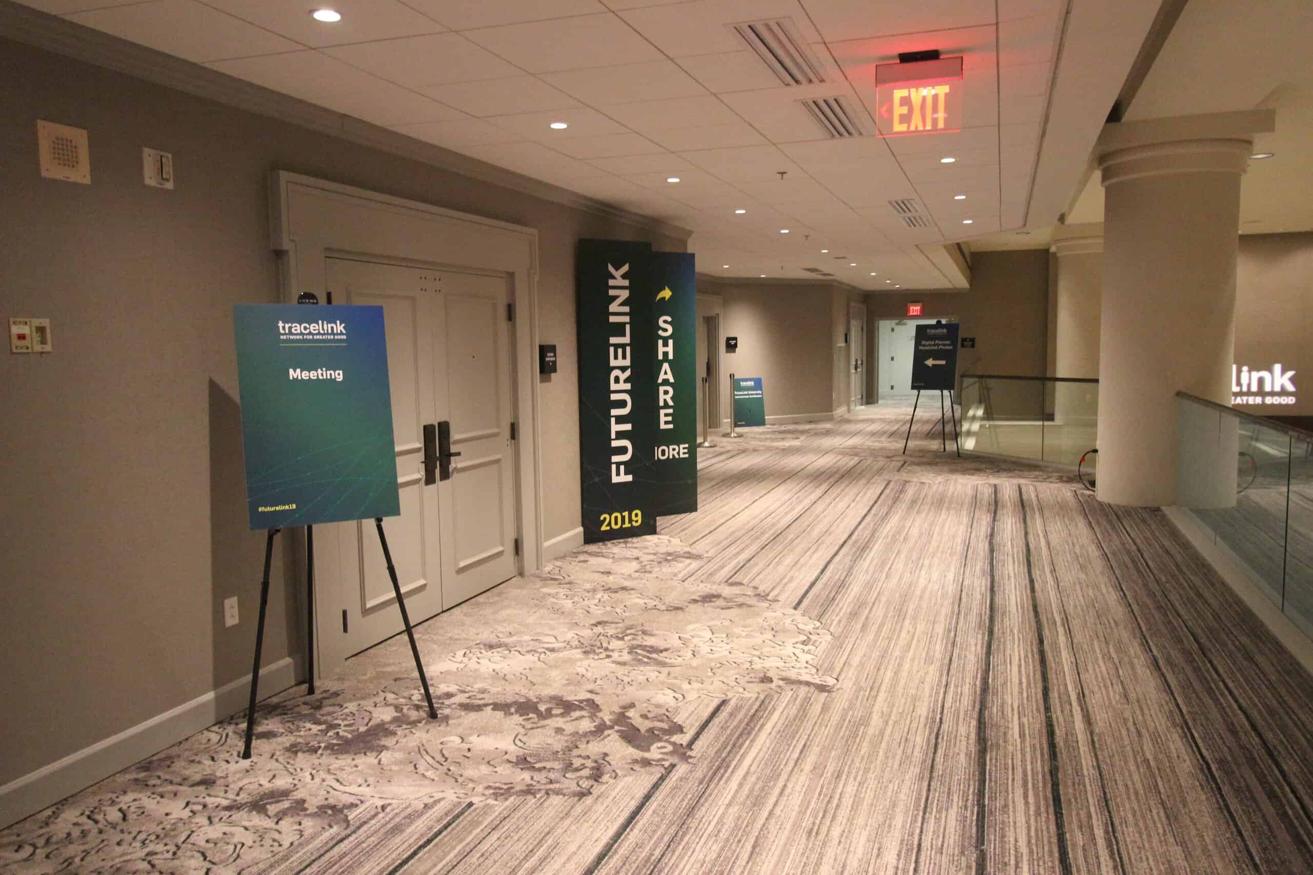Easel signs positioned in the hallways guide conference attendees to the appropriate rooms.