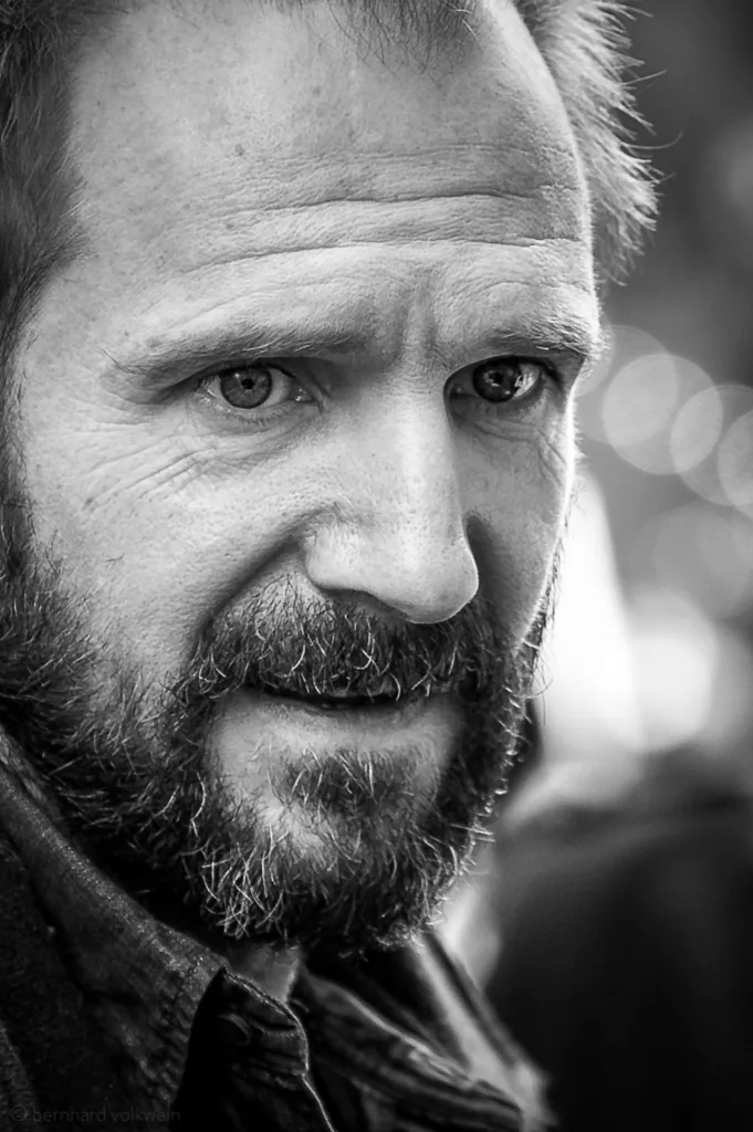 Dramatic high-contrast portrait of Ralph Fiennes at Berlinale, emphasizing intense facial expressions – part of the exhibition 'The Unseen Scene'.